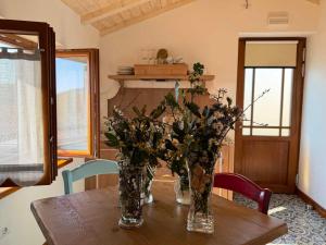 a wooden table with two vases with flowers on it at Agriturismo Fruske in Aurisina