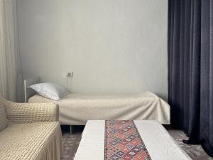 a room with two beds and a couch at "AlmUrUt" Guest House in Bokonbayevo