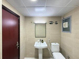 a bathroom with a sink and a toilet at Unmatched Location - A Large 2BR Sea-facing Flat in Sharjah +13 photos