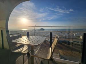 a table and chairs on a balcony with a view at Isola Bella - Luxe Verblijf op de Zeedijk met Panoramisch Uitzicht in Blankenberge