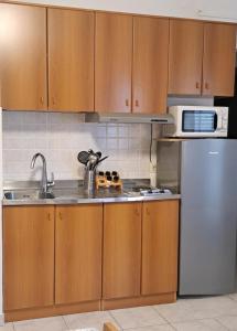 a kitchen with wooden cabinets and a stainless steel refrigerator at Studio apartman Olivera in Rovinj