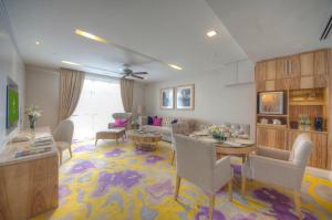 a living room with a couch and a table and chairs at The Chateau Spa & Wellness Resort in Bukit Tinggi