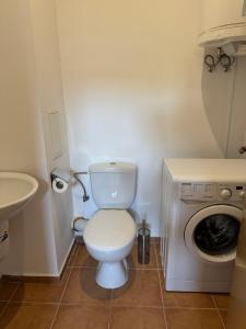a bathroom with a toilet and a washing machine at VP Bellevue in Ravda +25 photos