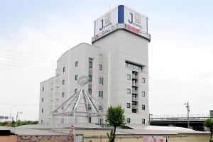 um edifício branco com uma placa em cima em Hotel Joy (Adult Only) em Komaki