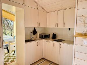 a kitchen with white cabinets and a sink and a table at 204 Hochwertiges Tiny House mit Wiesenblick in Bleckede