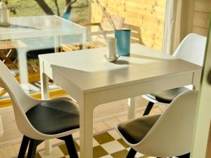 a white table and chairs in a room at 204 Hochwertiges Tiny House mit Wiesenblick in Bleckede