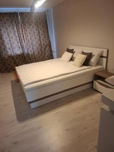 a bedroom with a bed with white sheets and pillows at SV Apartment in Jõhvi