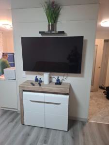 a flat screen tv on a wall with a white cabinet at SV Apartment in Jõhvi