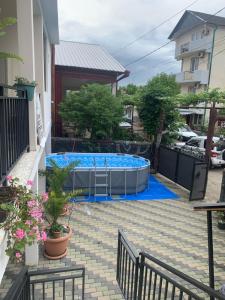 a swimming pool in a backyard with a blue poolvisor at LouNik Kobuleti in Kobuleti +8 photos
