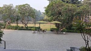 a patio with chairs and tables and umbrellas at Hotel Pallavi Grand in Panchkula