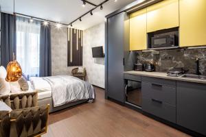 a bedroom with a bed and a kitchen with a sink at Super Central - Modern & Luxury in Budapest