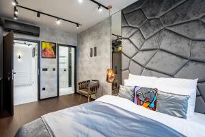 a bedroom with a large bed and a stone wall at Super Central - Modern & Luxury in Budapest