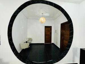 a large round mirror in a white room with a chair at Chez sesa in Dakar +6 photos