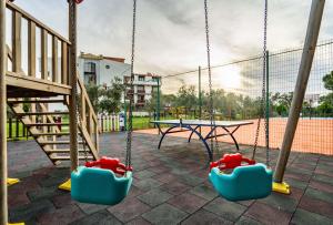 a swing set in a playground with a table at Helen Troya Hotel Geyikli in Çanakkale