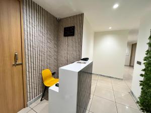 a yellow chair sits next to a desk in a lobby at Atithi in Hisār