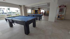 a room with three ping pong tables in it at SALINAS PARCK in Salinópolis