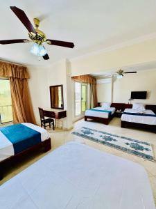 a bedroom with two beds and a ceiling fan at Bianco Matrouh Hotel in Marsa Matruh +24 photos