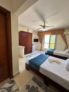 a bedroom with two beds and a ceiling fan at Bianco Matrouh Hotel in Marsa Matruh