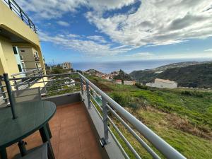 a balcony with a table and a view of the ocean at The View House in Ponta do Sol