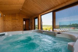 a jacuzzi tub in a room with windows at Zajęcze Domki in Zagórze Śląskie