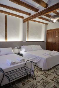 a bedroom with two beds and a chair in it at Masía El Losar - Casa Rural Exclusiva Castellón in Villafranca del Cid