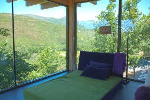 a room with a bed in front of a large window at Retiro Da Arminda in Canedo