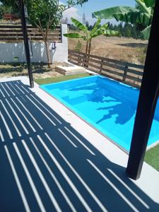 a pool in a backyard with a blue swimming pool at Elysian Suites in Ratzaklíon