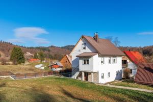 a white house with a brown roof at Valdora Forest Oasis - Spa Villa Fužine in Fužine