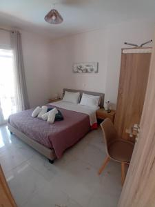 a bedroom with a large bed and a chair at Elysian Suites in Ratzaklíon