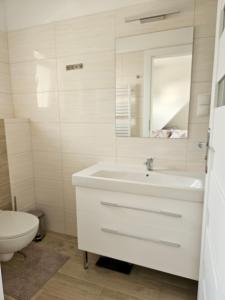 a white bathroom with a sink and a toilet at Zakątek przy Wydmie in Dziwnów +17 photos