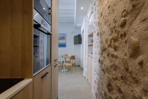 a kitchen with a stone wall and a table at Artemaris by Seaward Suites in Villajoyosa