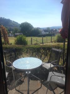 a table and chairs on a patio with a view of a field at Ferienhäuser Holenberg in Holenberg