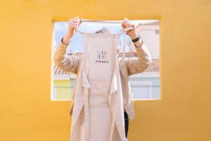 a woman is holding up apron in front of a window at Artemaris by Seaward Suites in Villajoyosa