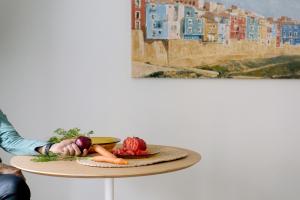 a person sitting at a table with a plate of vegetables at Artemaris by Seaward Suites in Villajoyosa +33 photos