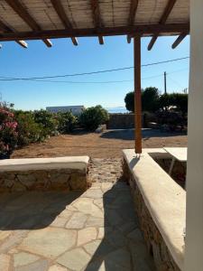 a patio with a bench and a picnic table at Lefkanemos in Tourlos +5 photos