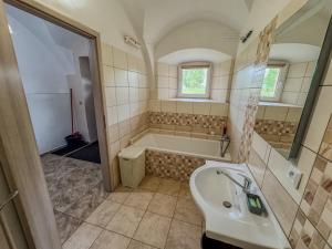 a bathroom with a tub and a sink at Apartmán 56 in Božanov