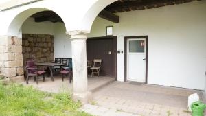 a patio with a table and chairs and a door at Apartmán 56 in Božanov +6 photos