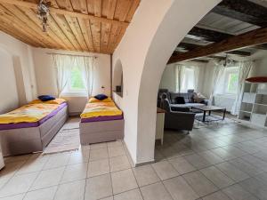 a bedroom with two beds and a living room at Apartmán 56 in Božanov