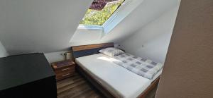 a small bed in a small room with a window at Ellenberg Appartements - Ferien- und Monteurs-Wohnung in Geislingen
