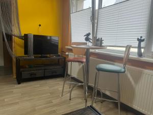 a living room with a table and chairs and a tv at Schwarzer Kater in Hochstetten-Dhaun