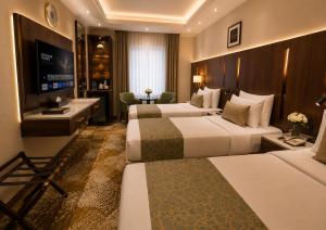 a hotel room with two beds and a television at هندباء Hindibaa in Mecca +39 photos