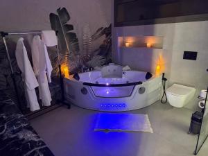 a bathroom with a white tub with lights in it at VILLA Noor Atlas in Aghmat +7 photos