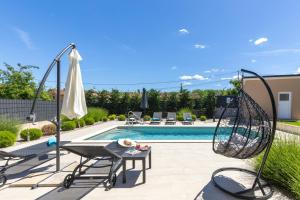 a patio with a swing and a swimming pool at Villa Egli s bazenom in Kršan