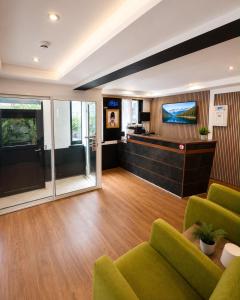 a living room with green chairs and a flat screen tv at Hotel Albergo in Brussels