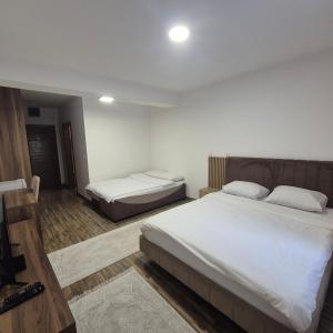 a hotel room with two beds with white sheets at Apartmani Han in Bijelo Polje