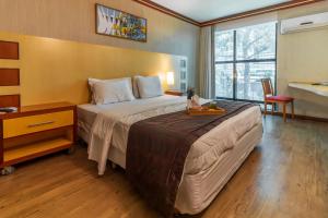 a hotel room with a large bed and a desk at Planalto Bittar Hotel e Eventos in Brasília