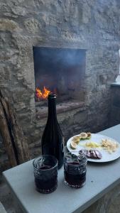 a table with a wine bottle and a plate of food at Tredici lune B&B in Finocchito