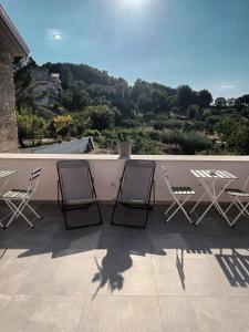 a group of chairs and tables on a balcony at Tredici lune B&B in Finocchito