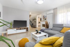 a living room with a couch and a tv at Villa Egli s bazenom in Kršan