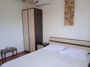 a bedroom with a white bed and a cabinet at Вилла Загора in Neodi